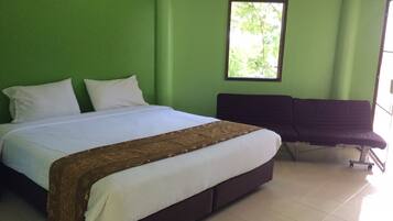 Una habitación con una cama, un banco y una ventana.