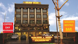 A hotel named 'Golden Grand' with a sign indicating 'Coffee Day Beverages' and 'Golden Restro Bar'. - Hotel Golden Grand (New Delhi)