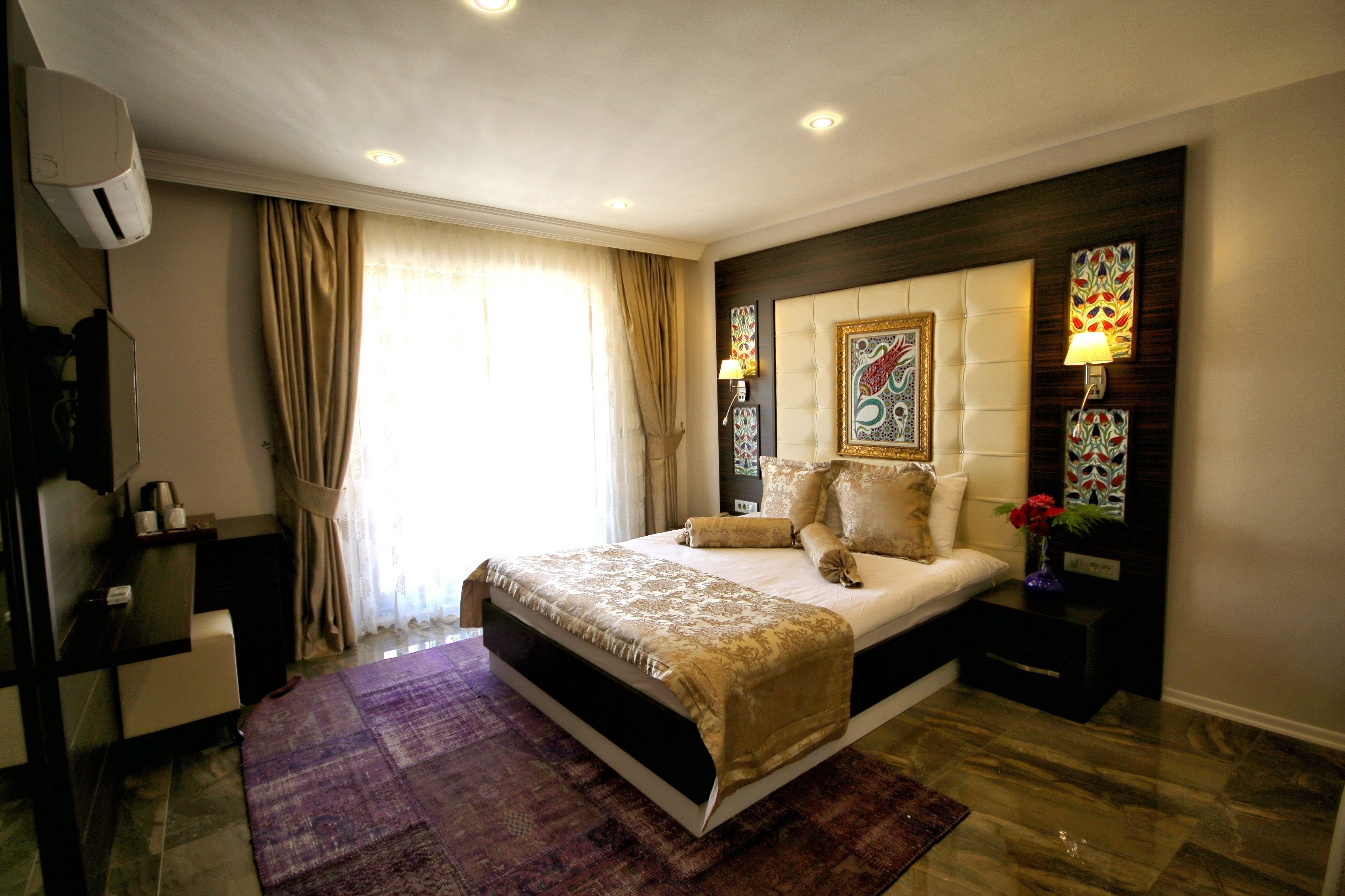 A modern hotel room with a large bed, a desk, and a vanity.