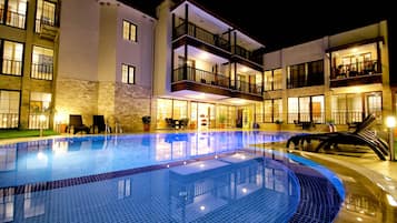 Relax by the pool surrounded by lounge chairs and tables, or enjoy the view from a balcony.