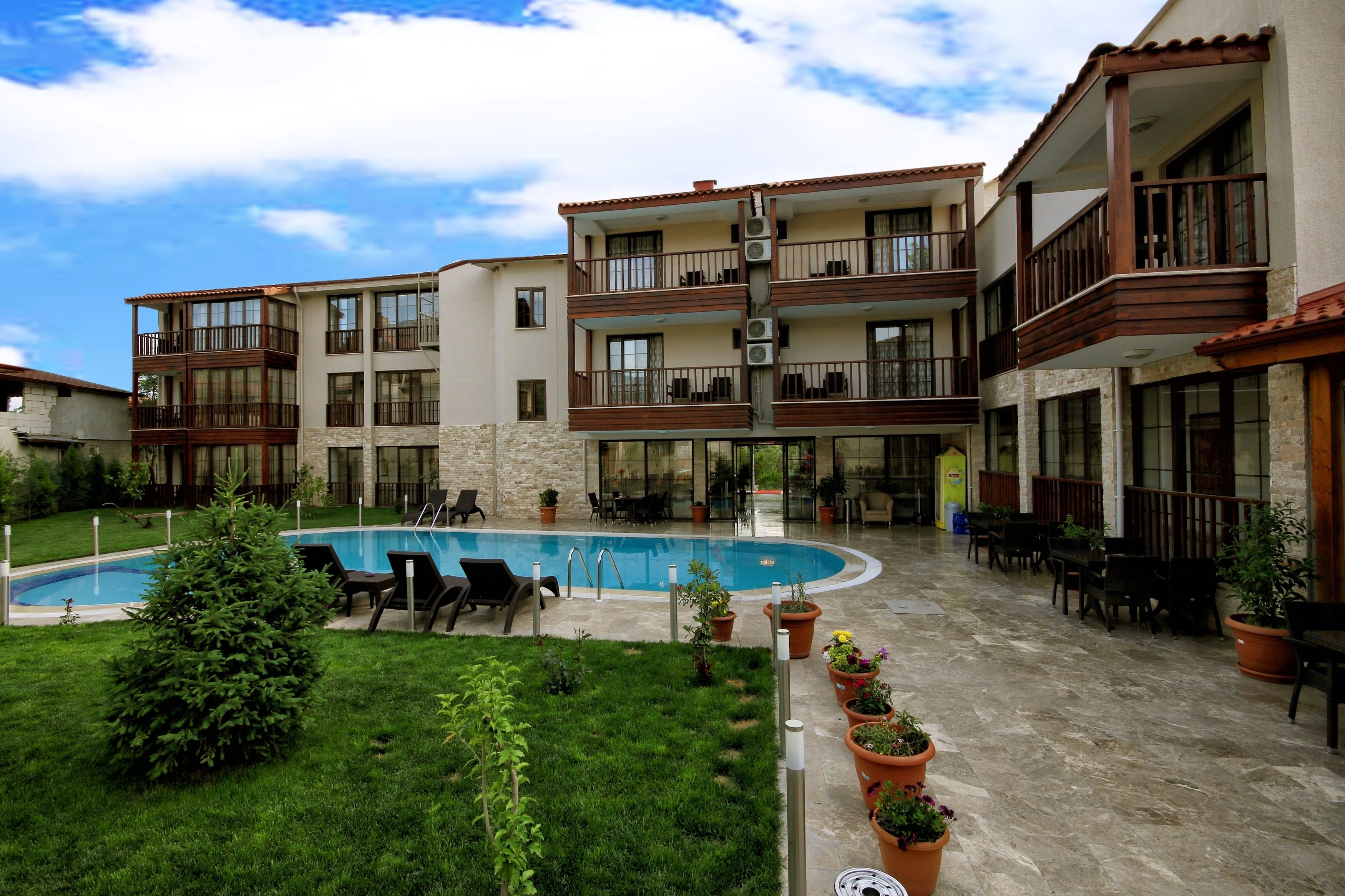 Un edificio de varios pisos con balcones, piscina y zonas de estar al aire libre.