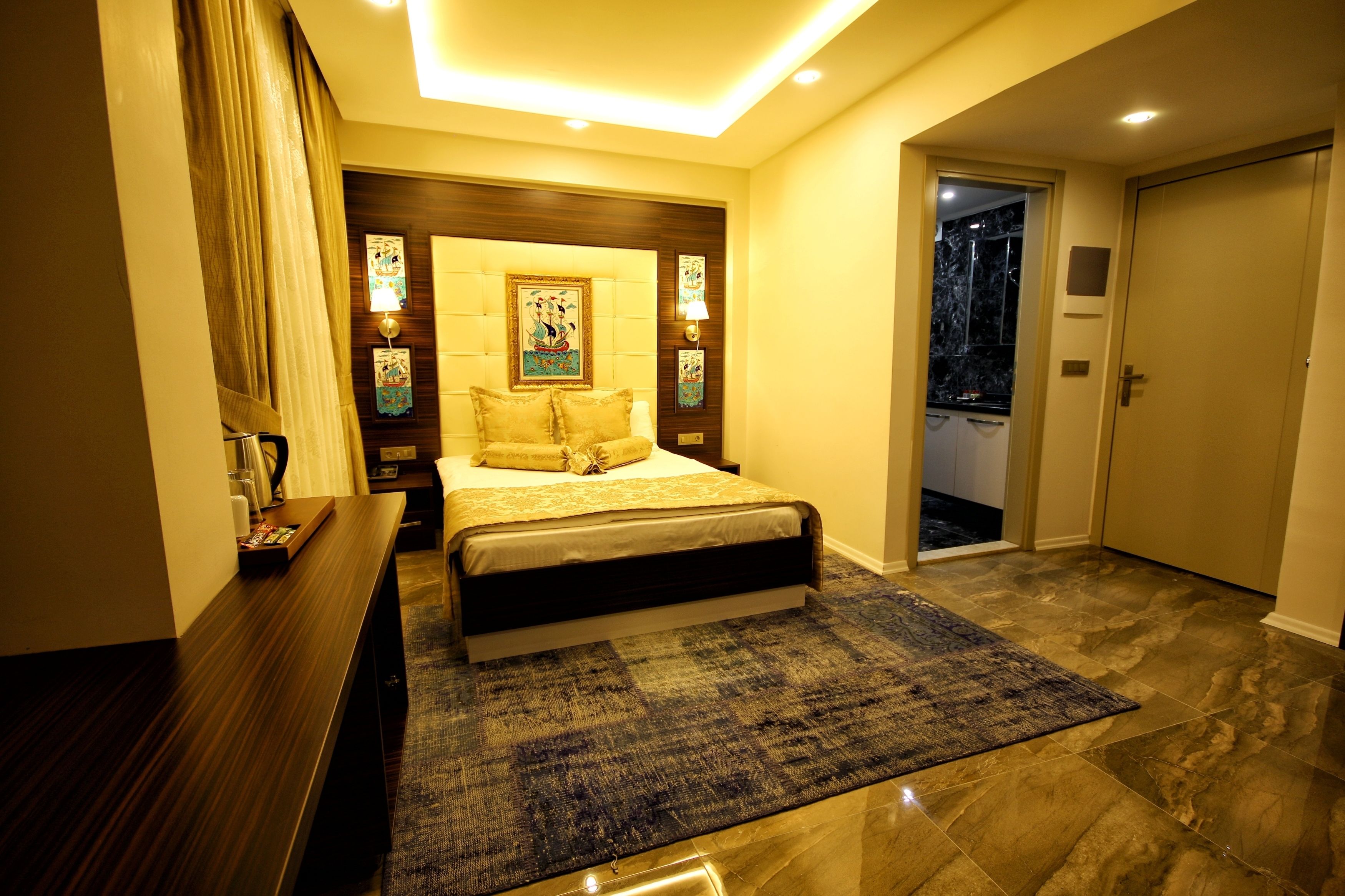 A modern bedroom with a large bed, a wooden headboard, and a nightstand.
