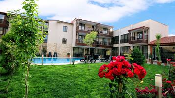 Um hotel com piscina, área de estar ao ar livre e um jardim bem cuidado.