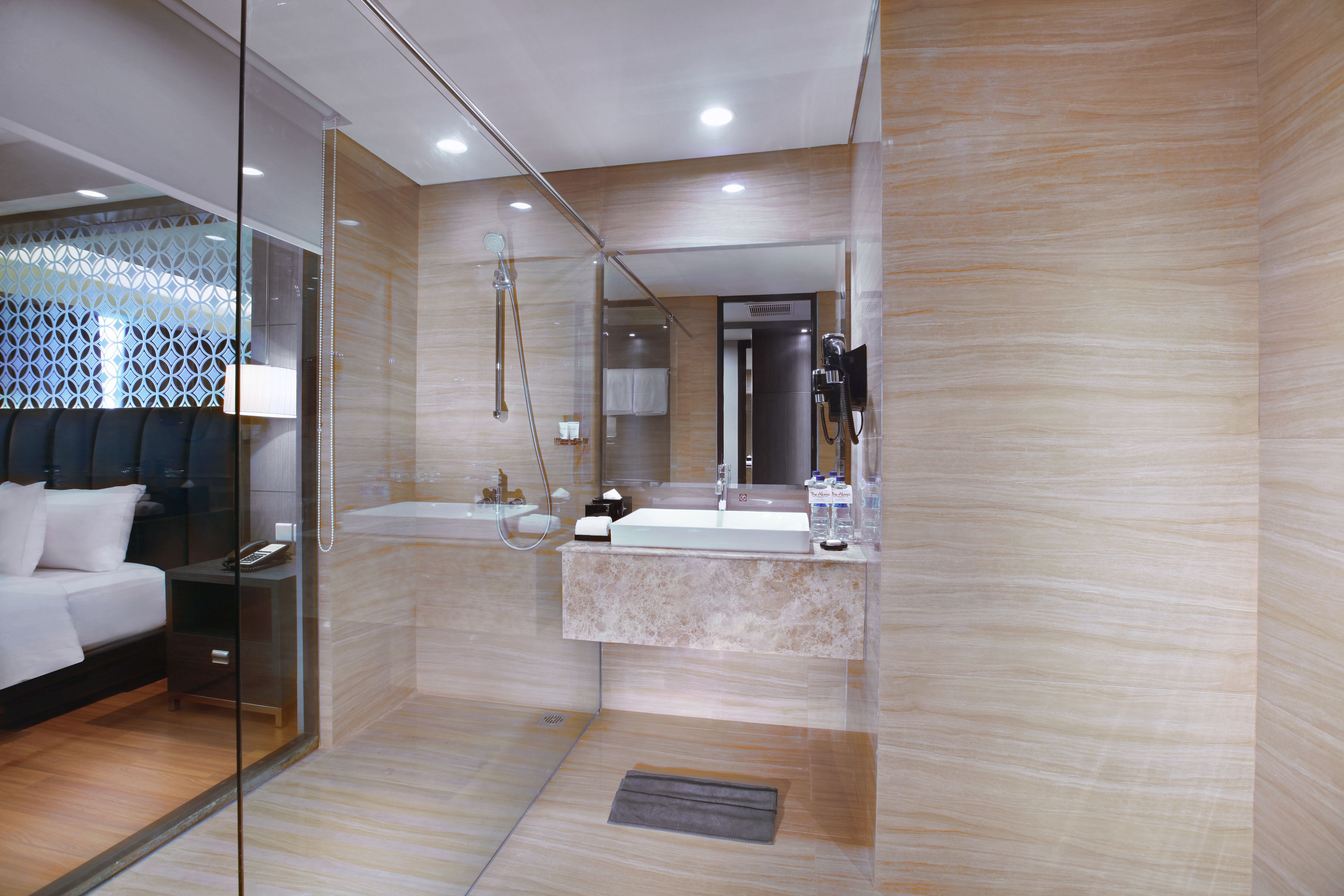 Un baño moderno con ducha envuelta en vidrio, un lavamanos blanco y un espejo grande.