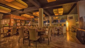 Un restaurante espacioso con techos altos, luminarias modernas y una zona de bar.