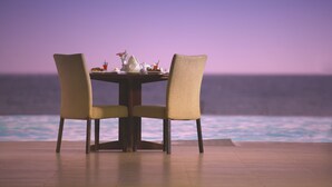 Una mesa de comedor con sillas y vista al océano.