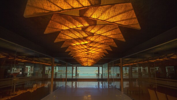 Un interior moderno con una pared de vidrio que ofrece vistas al mar.