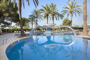 A swimming pool with a circular fountain, surrounded by palm trees and lounge chairs. - Mar Hotels Playa de Muro Suites (Muro)
