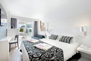 Una habitación de hotel moderna con una cama grande, un escritorio y vistas al exterior.