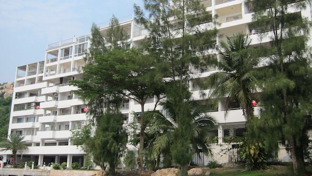 A multi-story hotel with balconies, surrounded by trees and a rocky landscape. - Sammuk Resort (Chonburi)