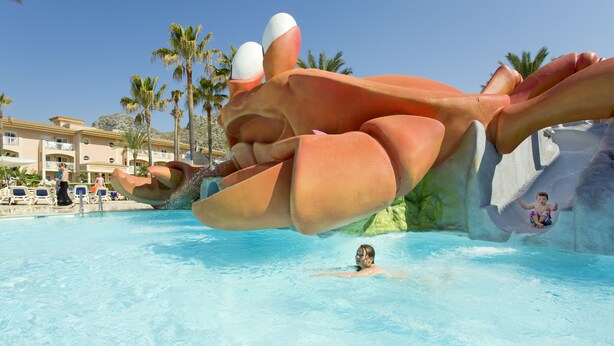 A pool with a large, colorful water slide shaped like a crab. - Mar Hotels Playa Mar & Spa (Pollenca)