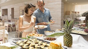 A buffet setup with various food items and a pineapple centerpiece. - Mar Hotels Playa Mar & Spa (Pollenca)