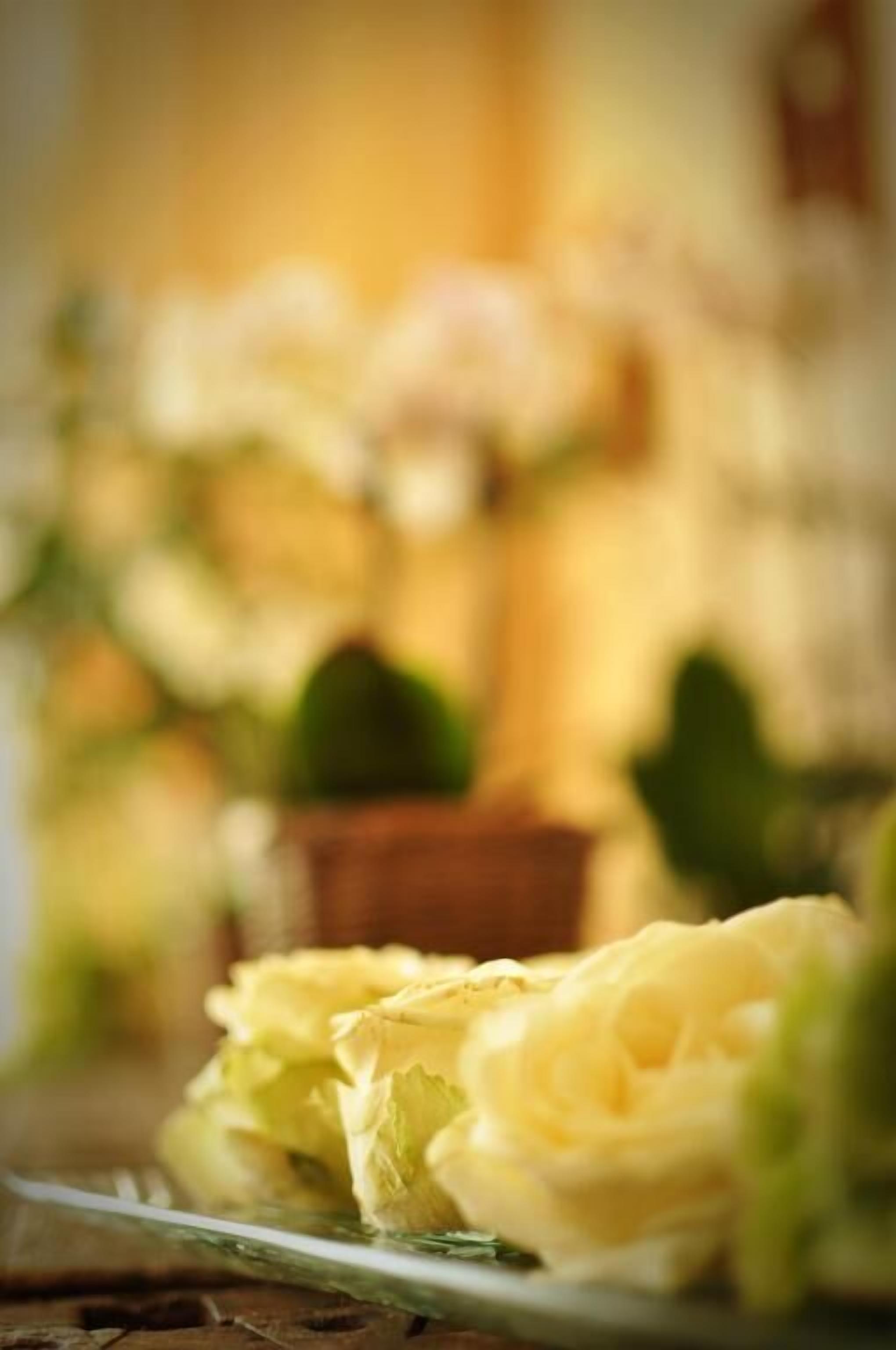 A close-up of a table with a plate of yellow flowers.