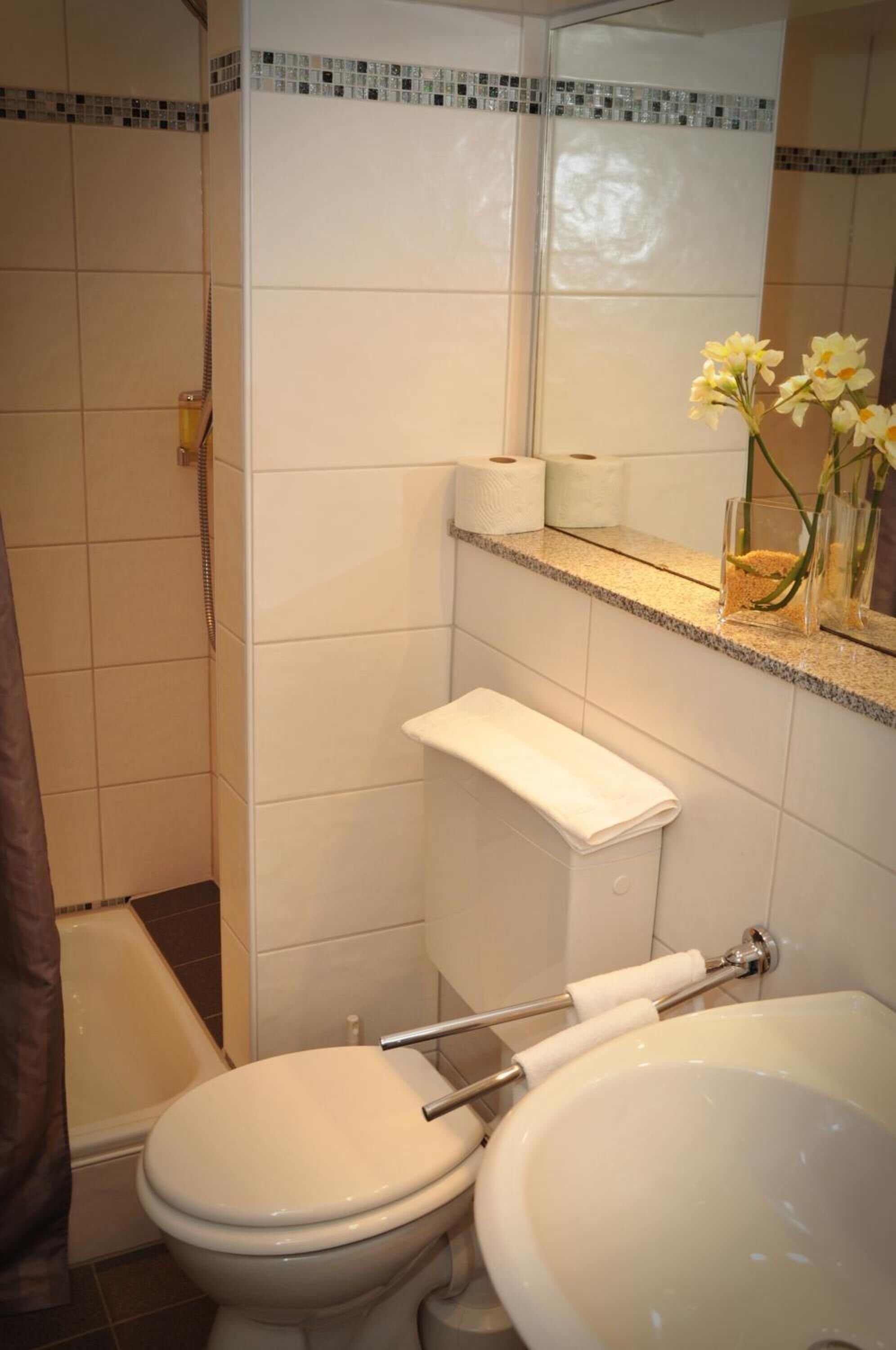 A bathroom with a toilet, sink, and shower.