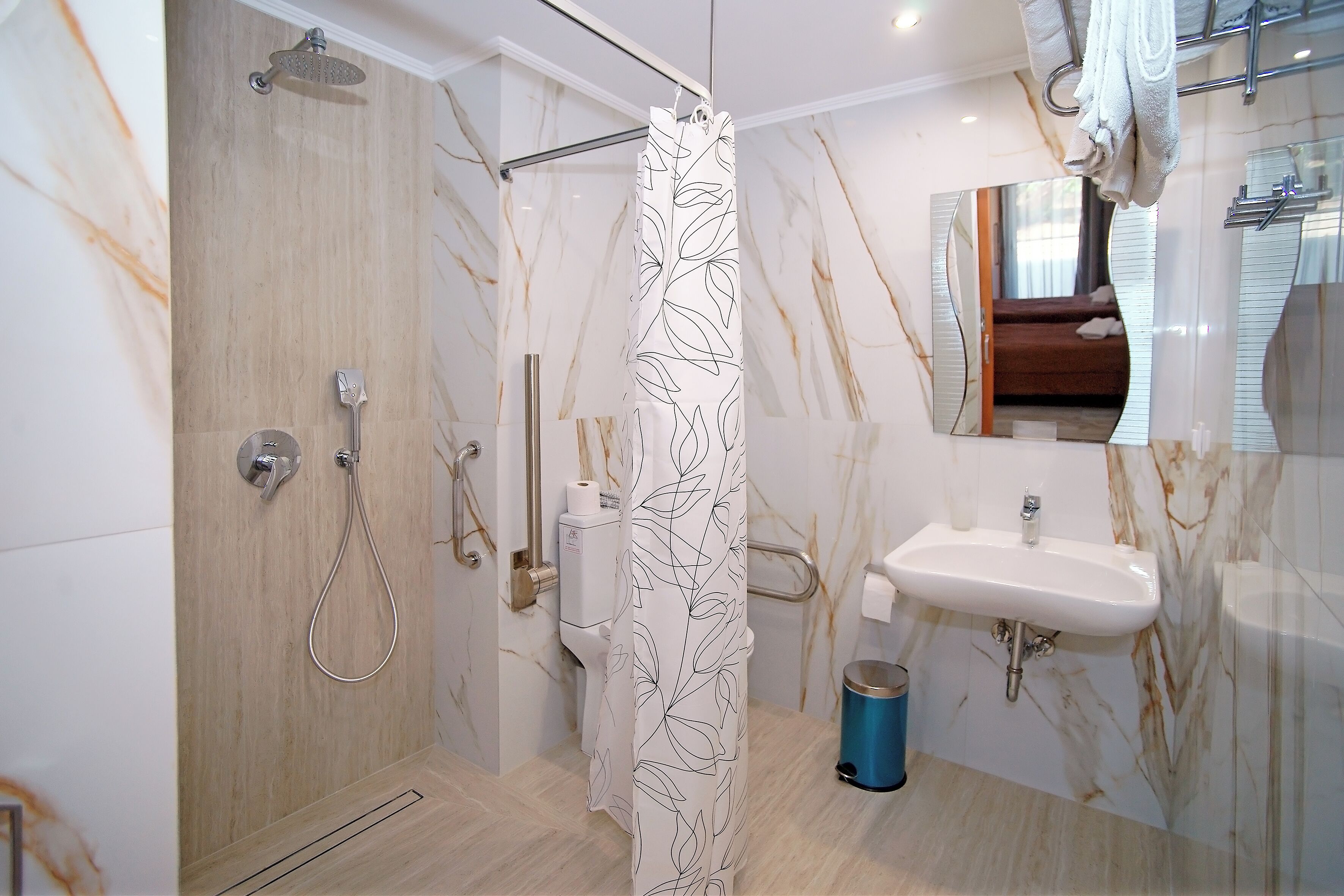 Une salle de bain moderne équipée d’une douche, de toilettes, d’un lavabo et d’un miroir.