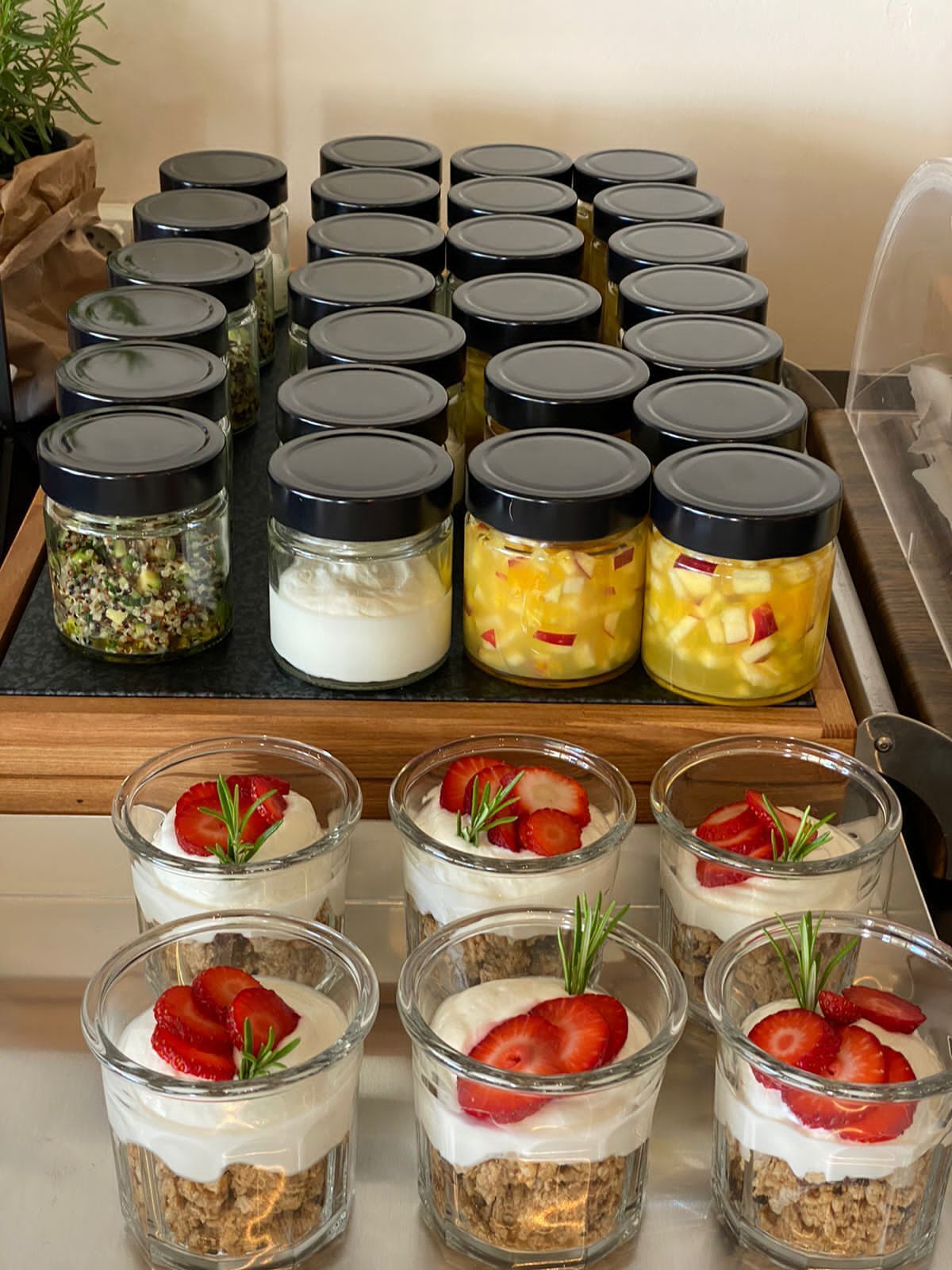 A display of food items, including jars with various contents and small glass containers with layered desserts.