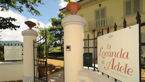 A reception sign for Villa Torribelle, Villa I Giardini, and La Locanda di Adele, indicating a bed and breakfast establishment.