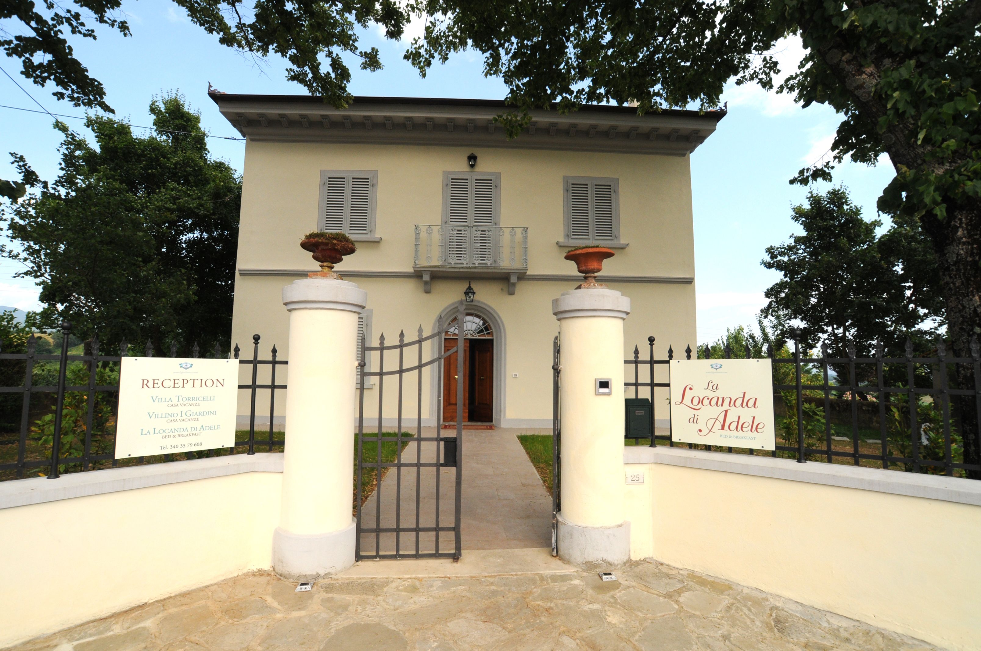 A reception area with a sign indicating Villa Torribelle, a reception desk, and a pathway leading to the entrance.