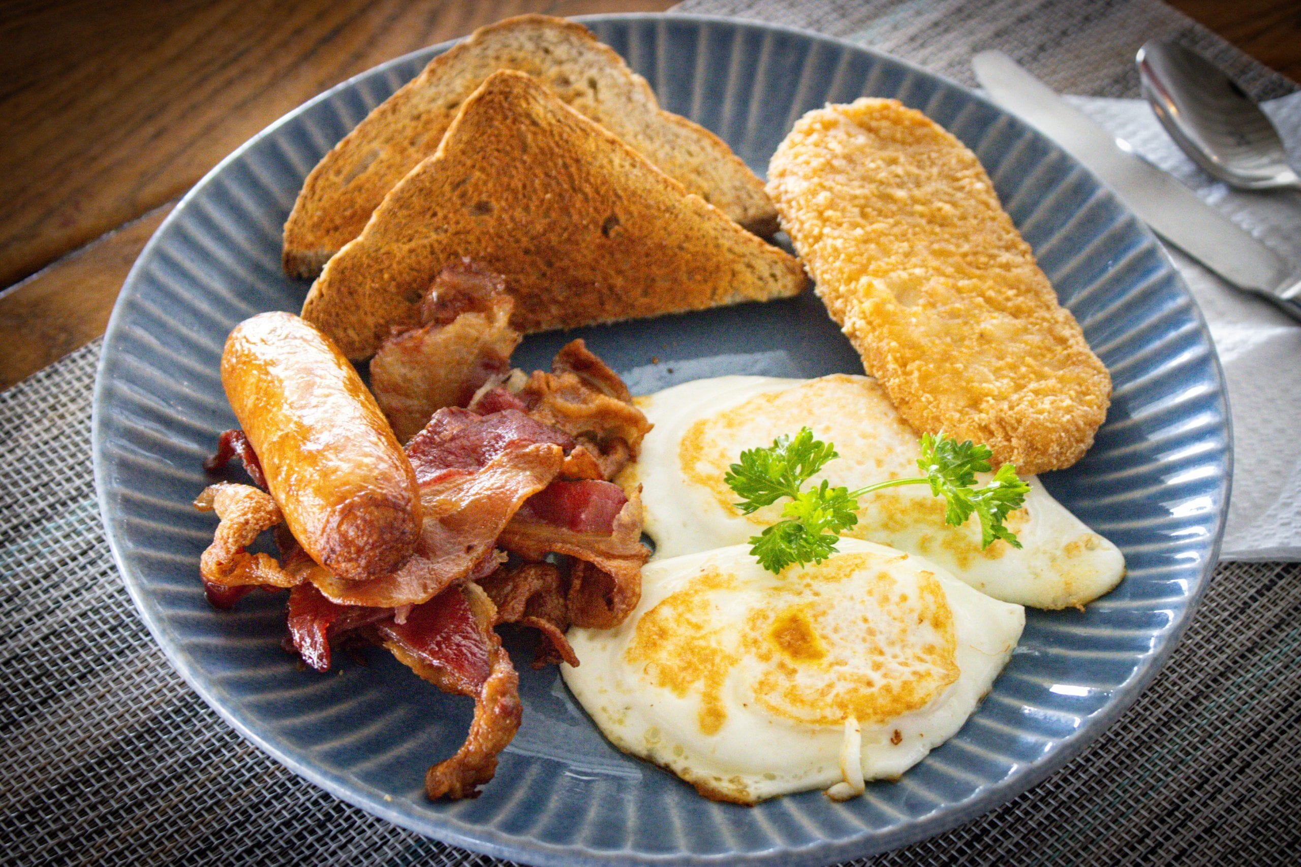 A plate with toast, fried eggs, and bacon.