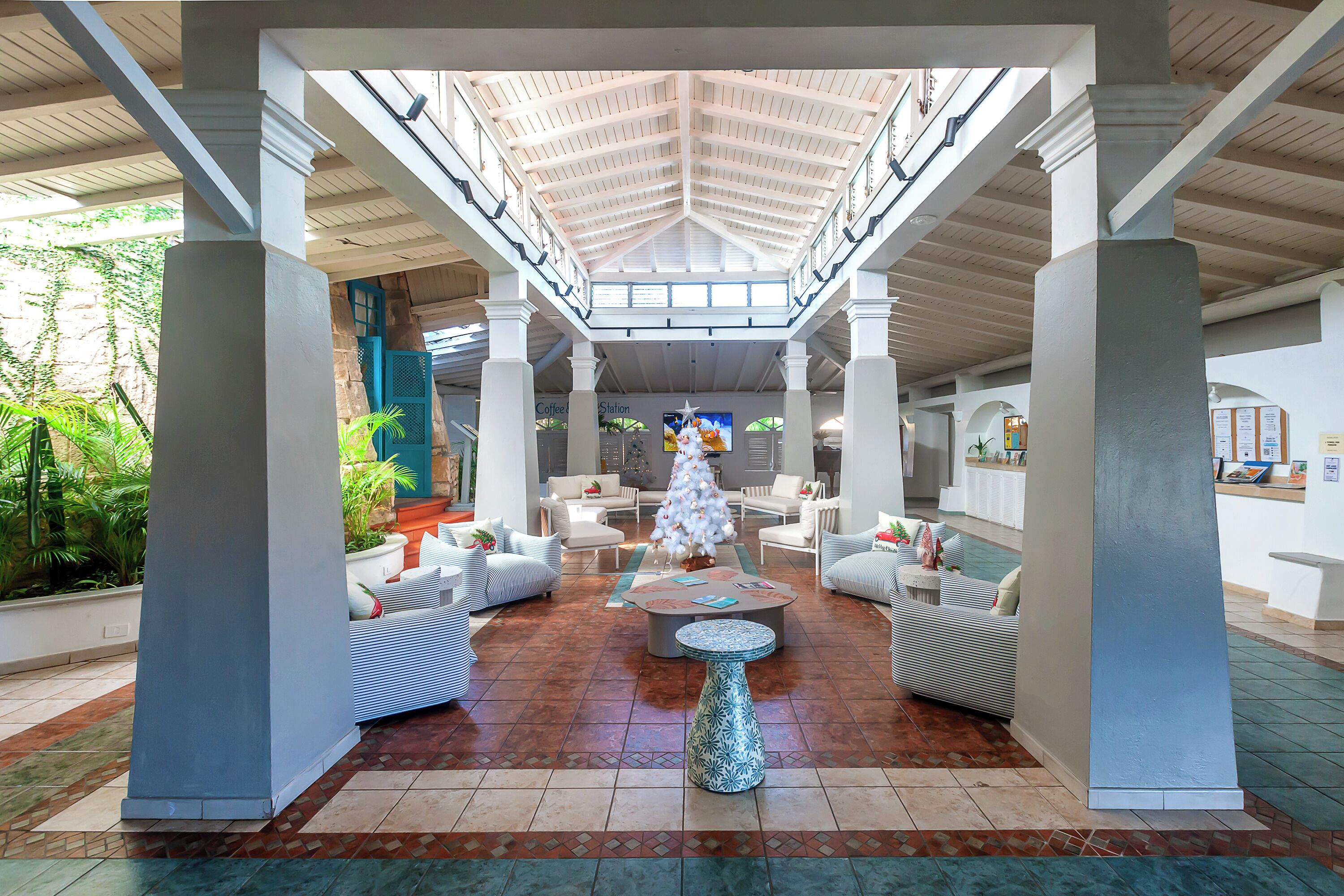 A spacious lobby with a high ceiling, a Christmas tree, and comfortable seating areas.