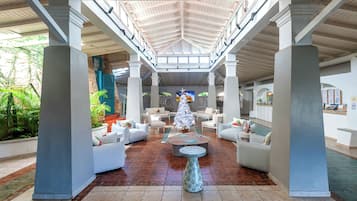 A spacious lobby with a high ceiling, a Christmas tree, and comfortable seating areas.