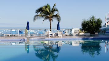 Piscine extérieure, parasols de plage, chaises longues