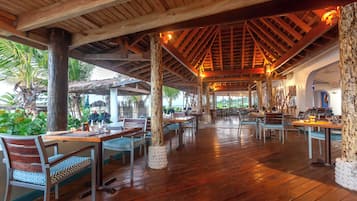 Un restaurante al aire libre con vigas de madera y mesas.