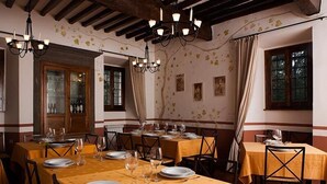 A dining area with tables set for a meal, featuring a traditional wooden ceiling and wall decor. - Agriturismo La Topaia (Borgo San Lorenzo)