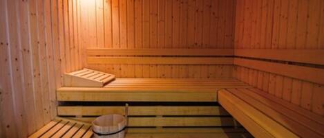 Un sauna en bois avec des bancs et un seau.