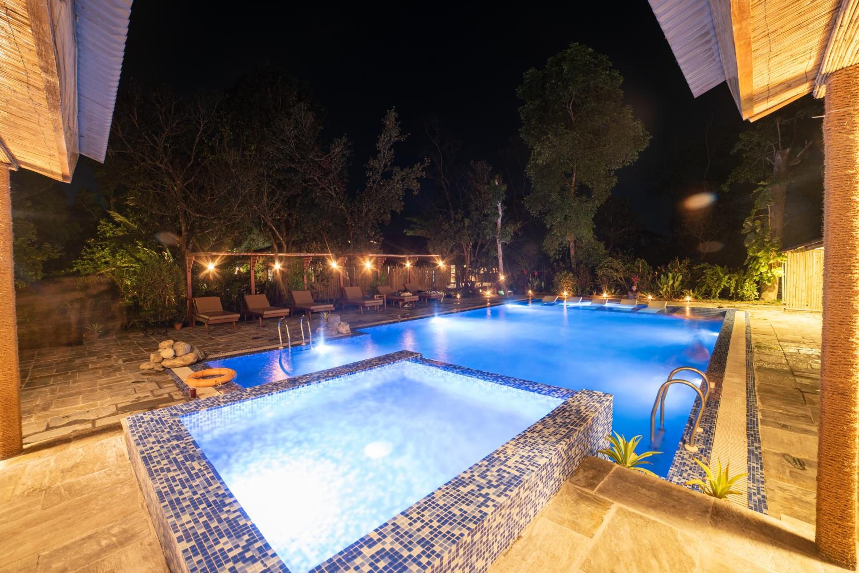 Una piscina al aire libre, sombrillas, sillones reclinables de piscina