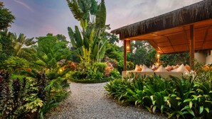 A garden pathway leading to a structure with a thatched roof. - GREEN MANSIONS JUNGLE RESORT (Sauraha)