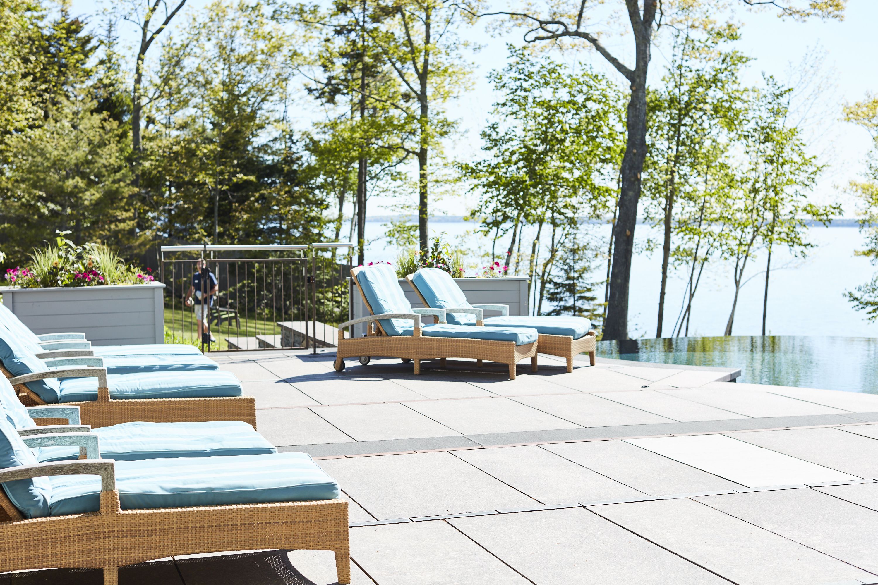 Un espace aménagé au bord de la piscine, avec des fauteuils de relaxation en osier et un petit coin salon abrité.