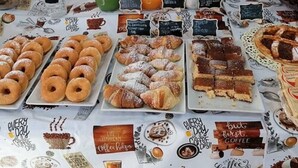 Un buffet de petit-déjeuner proposant une variété de viennoiseries, de boissons et différentes sortes de café.