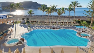 Piscine extérieure, parasols de plage, chaises longues