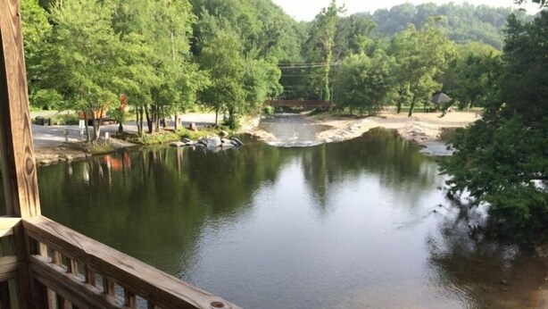 A view of a river from a wooden deck with a railing. - Drama Inn (Cherokee)