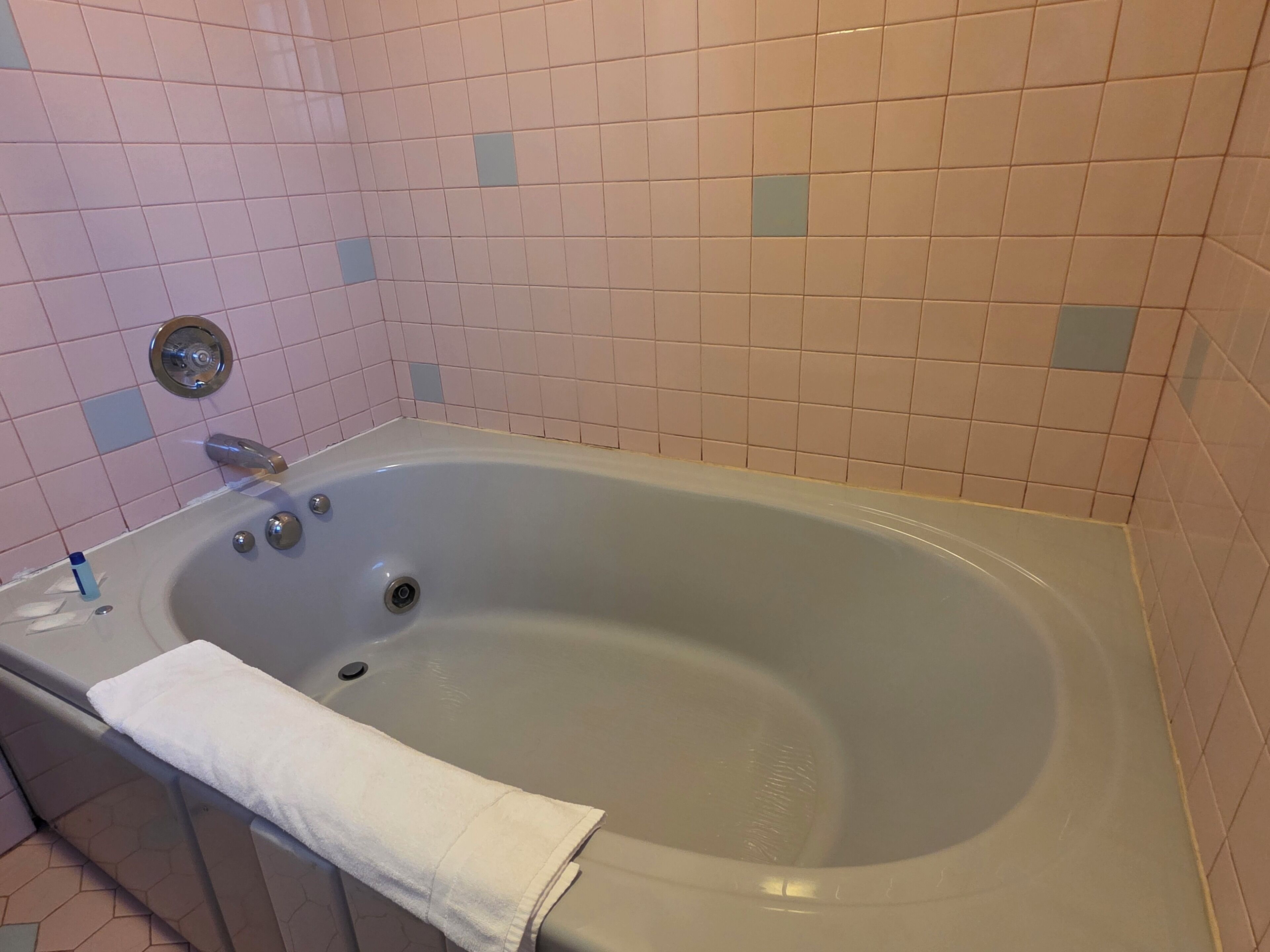 Un baño con una bañera, un grifo y una toalla.