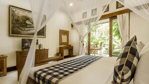 Una camera da letto con un letto, una scrivania, una sedia e un'ampia finestra vista sul verde.