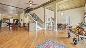 A spacious interior with a wooden floor, a staircase, and a dining area with chairs and tables. - Suites at The Red Rock Vacation rentals (Hot Springs)
