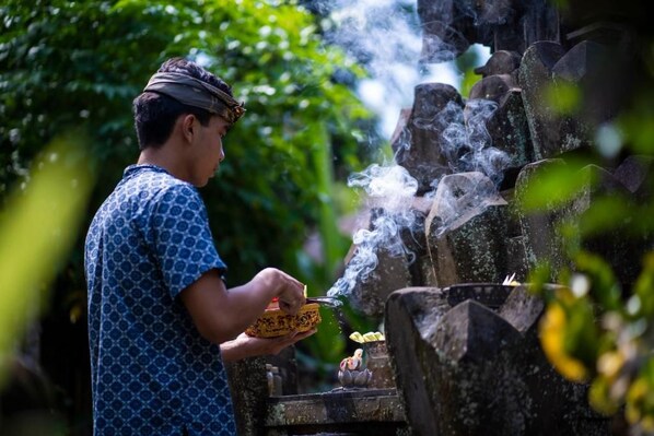 A person cooking outdoors with smoke rising from a grill.