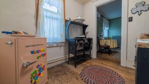 A room with a vintage refrigerator, a stove, and a wooden floor. - The Maid's Quarters Bed Breakfast & Tearoom (Pottsville)