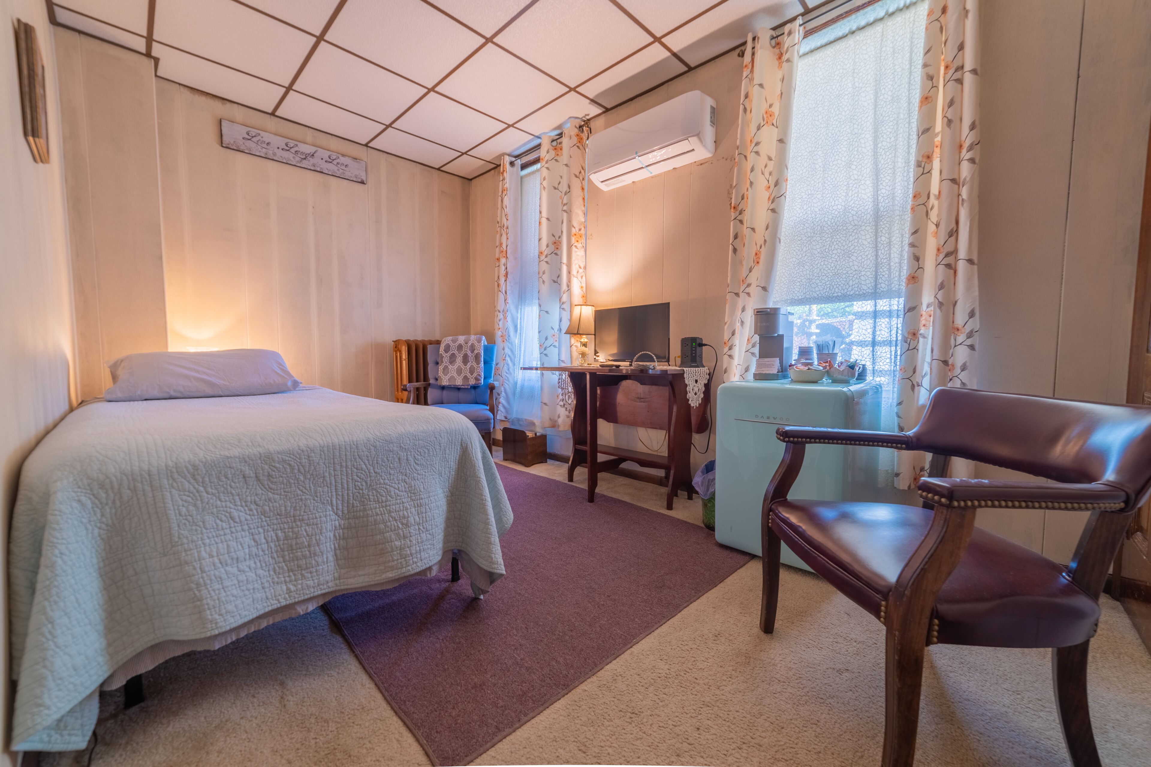 Een hotelkamer met een bed, een bureau, een stoel en een televisie.