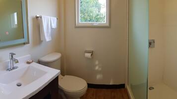 A bathroom with a white sink, toilet, and shower.