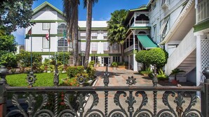 Un edificio de estilo colonial con un patio central, rodeado de abundante vegetación y palmeras.