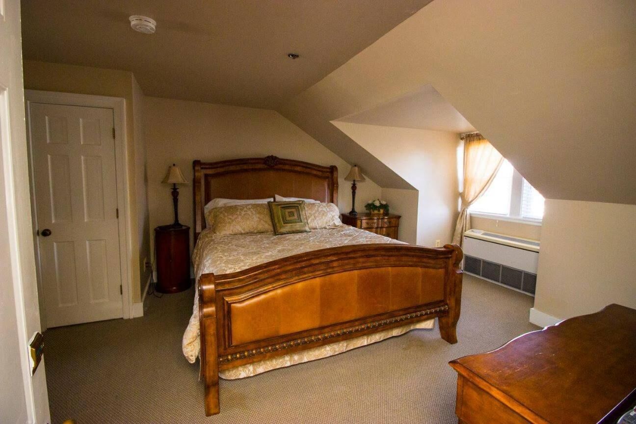 Un dormitorio con cama de madera, una mesita de noche, una lámpara y un radiador.