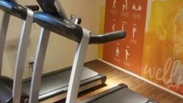 A gym with treadmills and a wall with fitness illustrations.