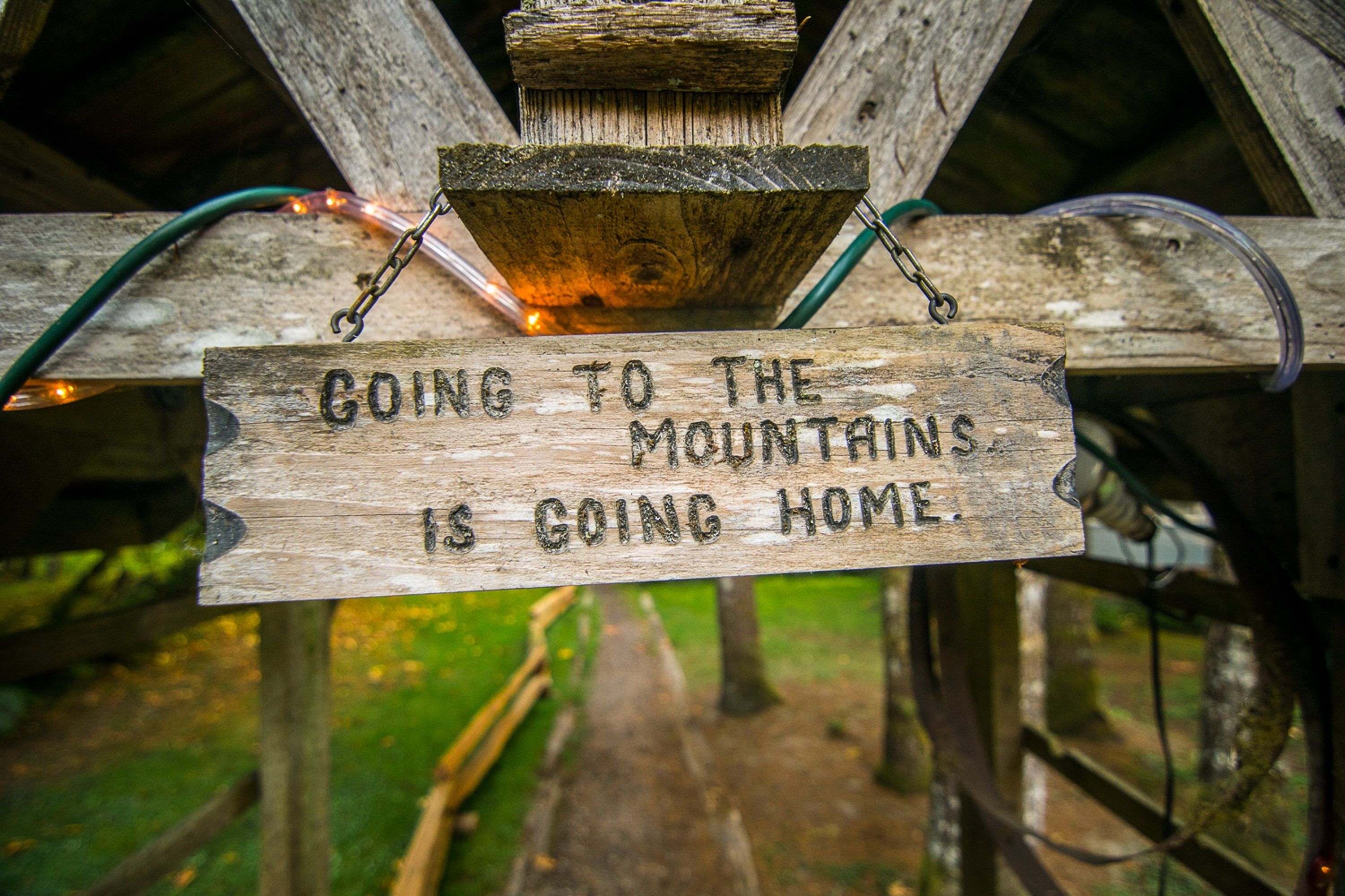 A wooden sign with the text "Going to the mountains is going home."
