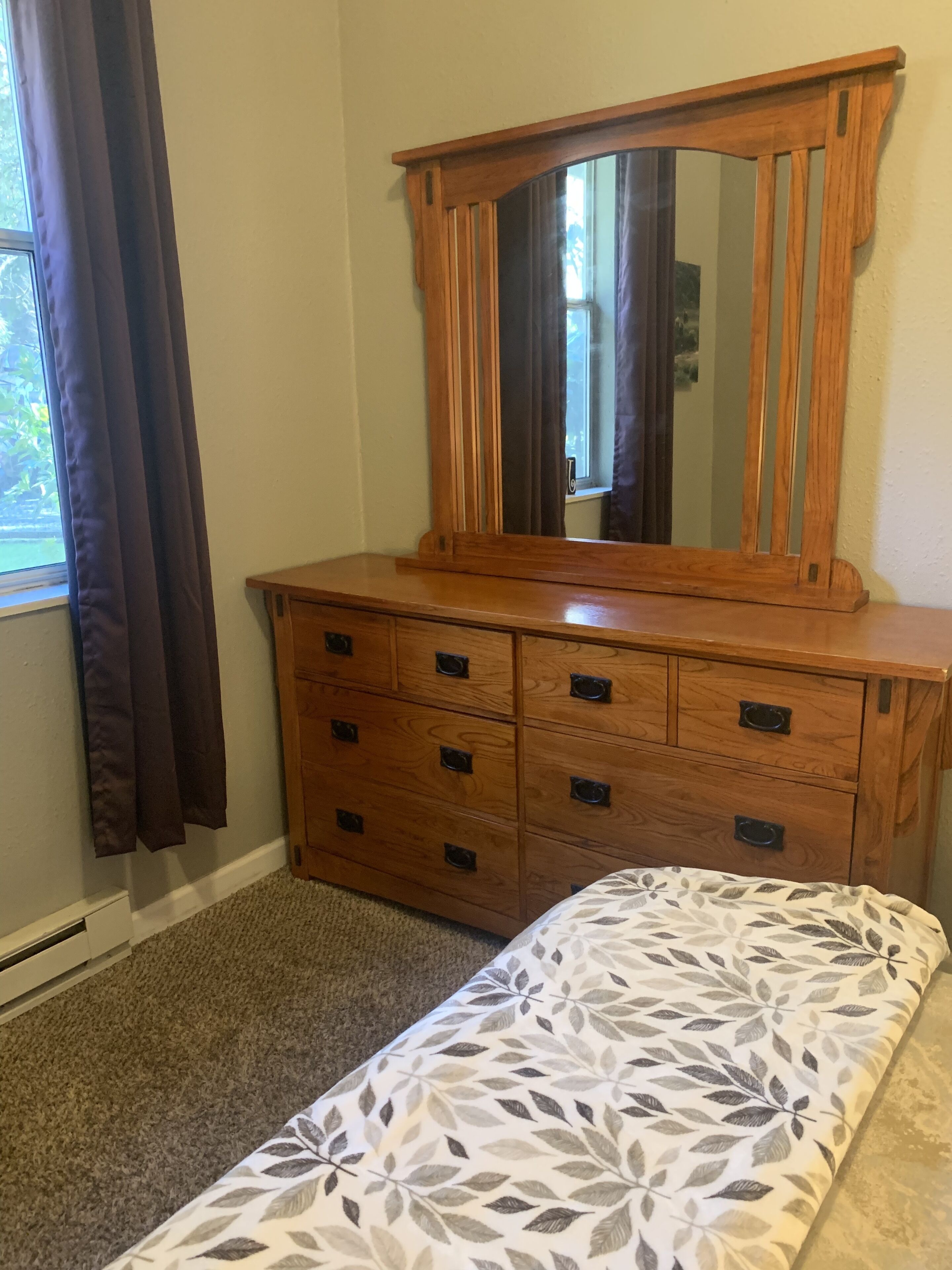 Une commode en bois avec de nombreux tiroirs et un miroir au-dessus.