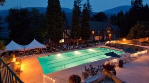 Una piscina al aire libre, sombrillas, sillones reclinables de piscina