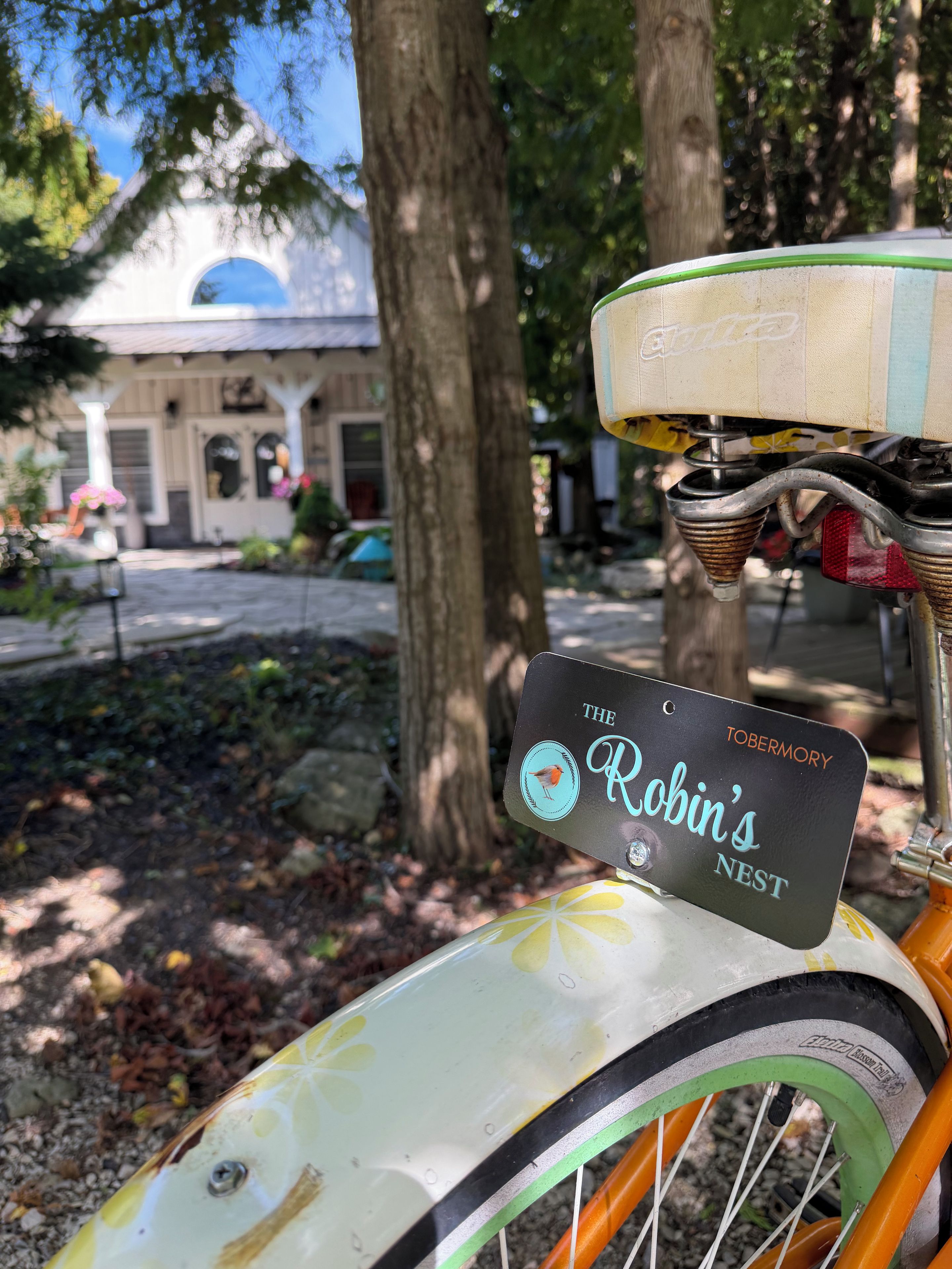 A bicycle with a license plate that reads 'The Robin's Nest' and a building with a dome in the background.