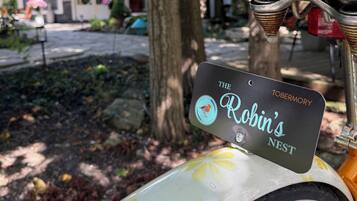 A bicycle with a license plate that reads 'The Robin's Nest' and a building with a dome in the background.